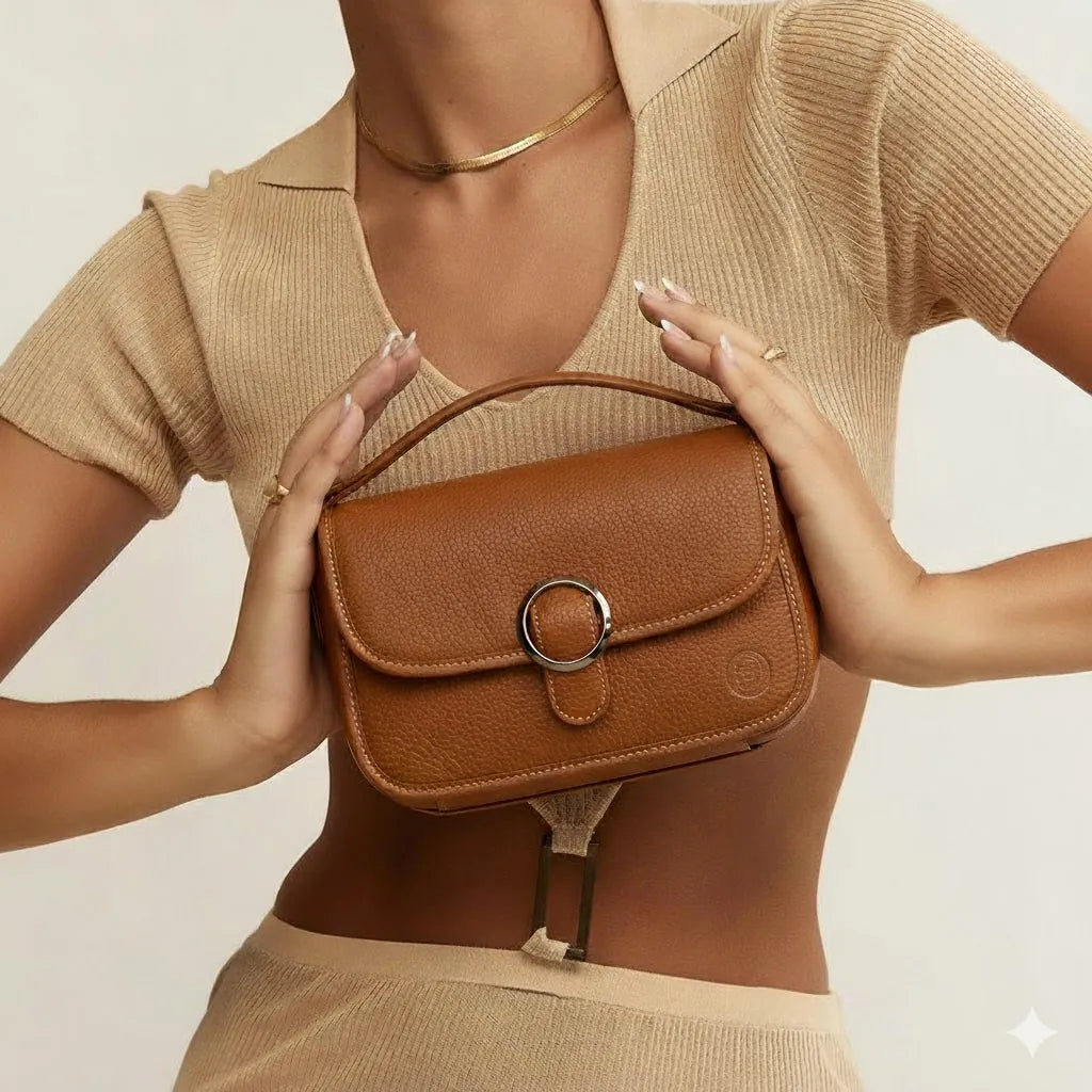 A woman holding a woven leather handbag